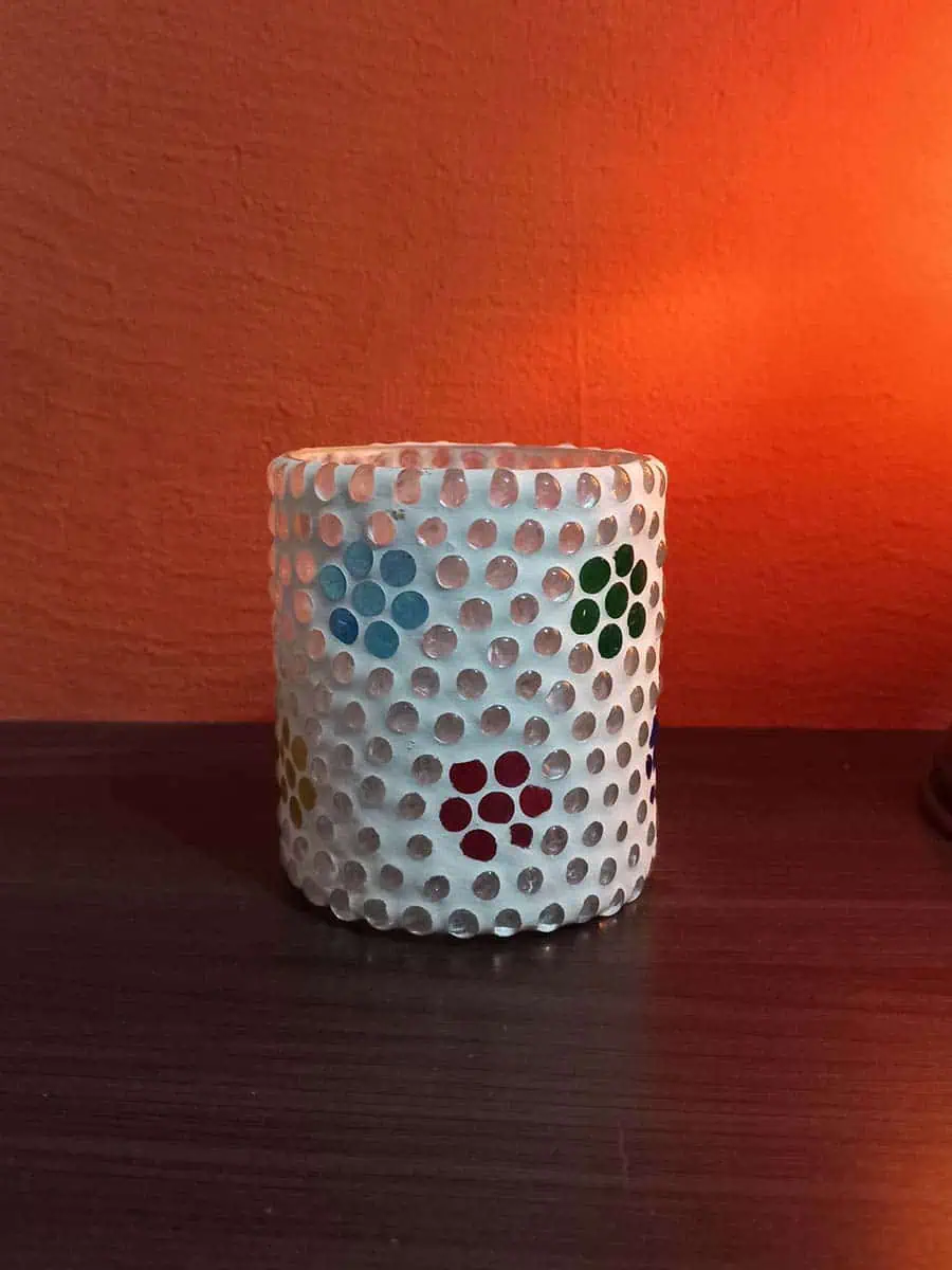 Portavela de vidrio blanco con flores