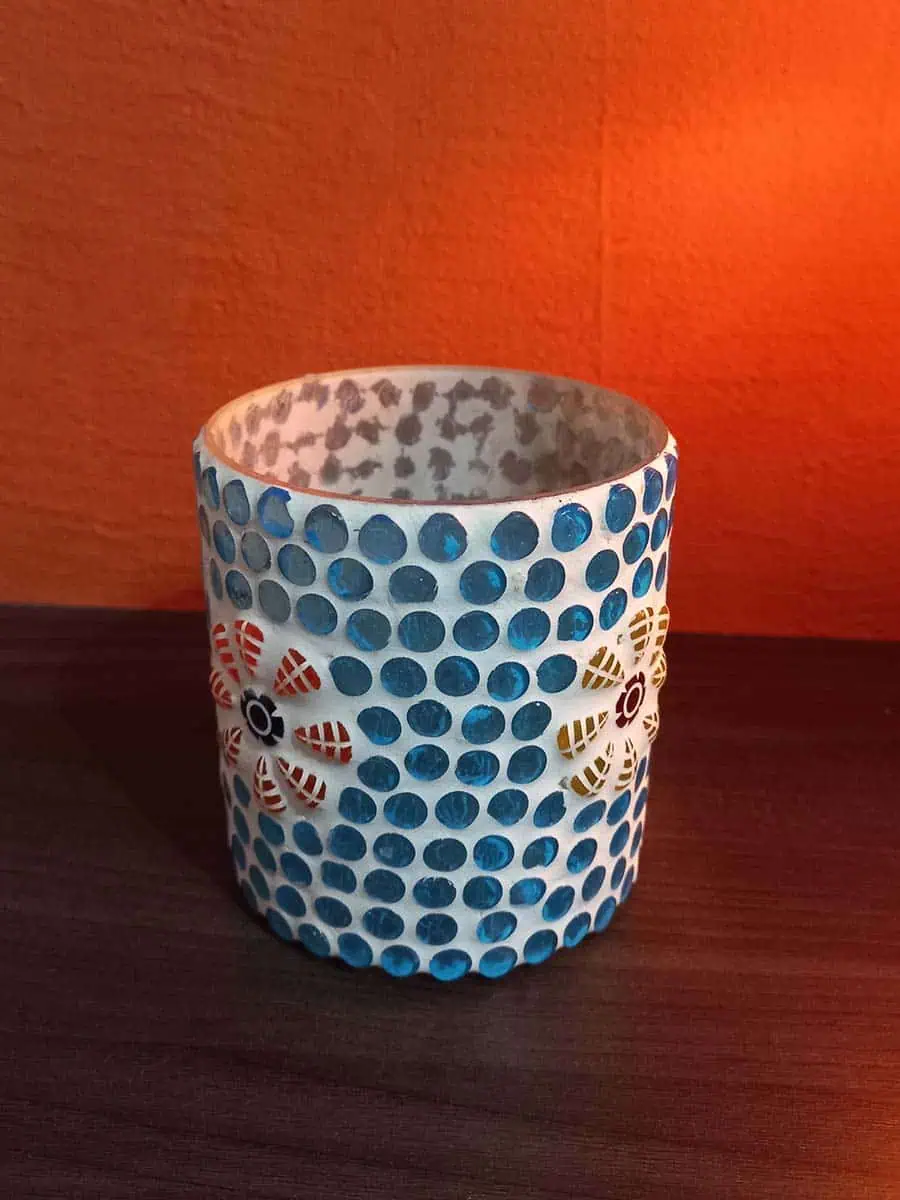 Portavela de vidrio celeste con flores