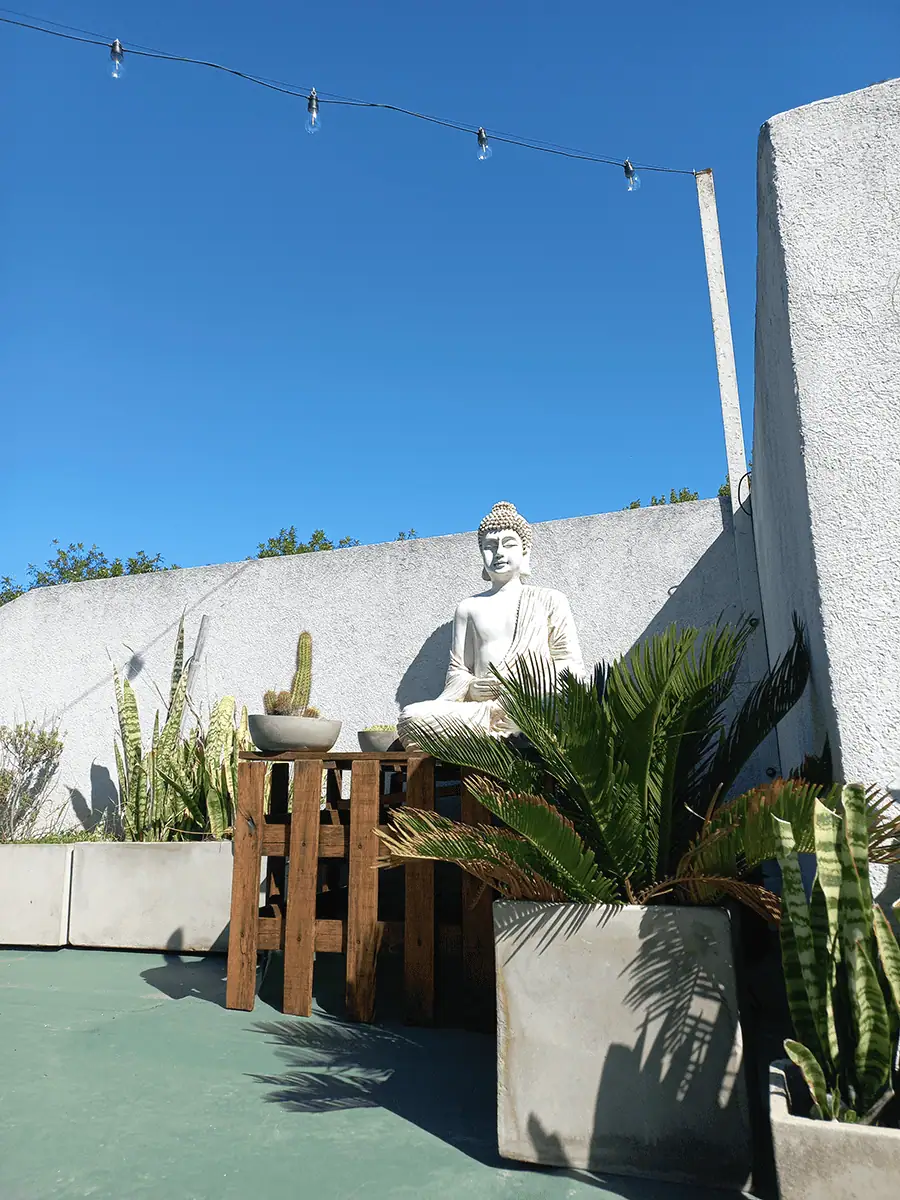 Buda de resina para exterior grande de meditacion decorando un espacio zen