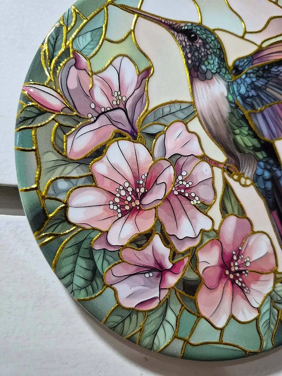 Colgante decorativo de pared de cerámica con un colibrí rodeado de flores rosadas y violetas