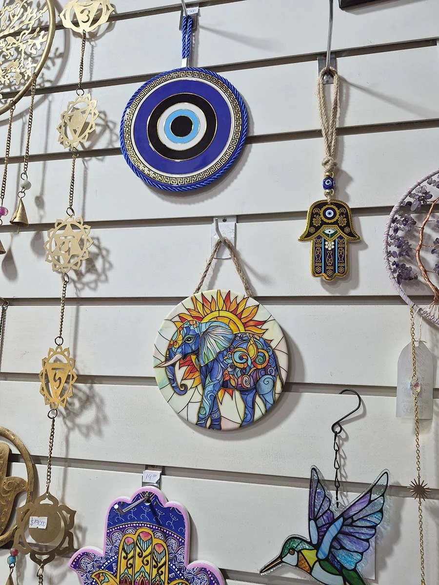 Colgante decorativo de pared de cerámica con un elefante frente a un sol naciente en tonos dorados y anaranjados
