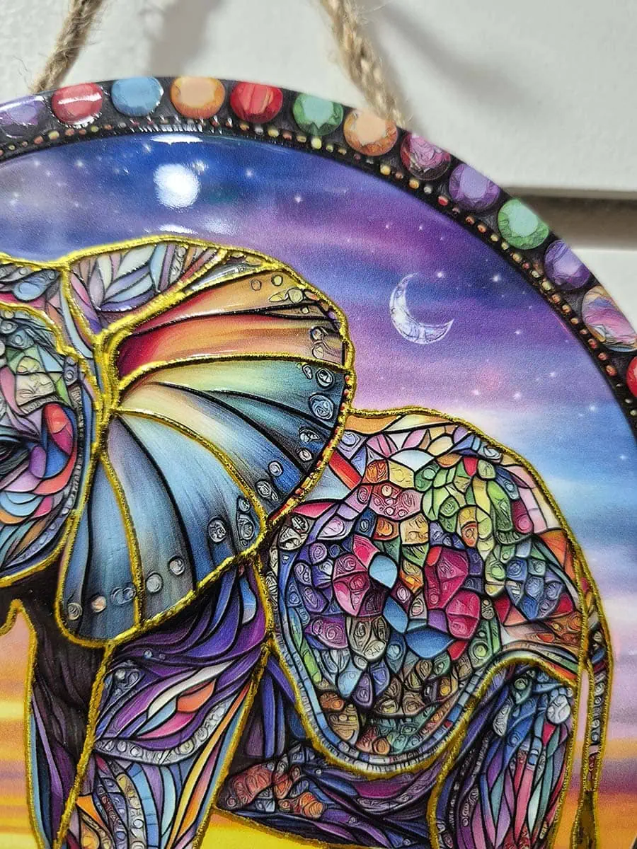 Colgante de pared redondo de cerámica con elefante colorido sobre un paisaje de anochecer