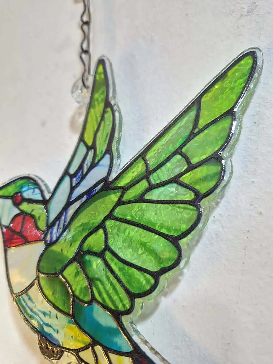 Colgante decorativo de colibrí en vitró verde con detalles rojos y campana de metal