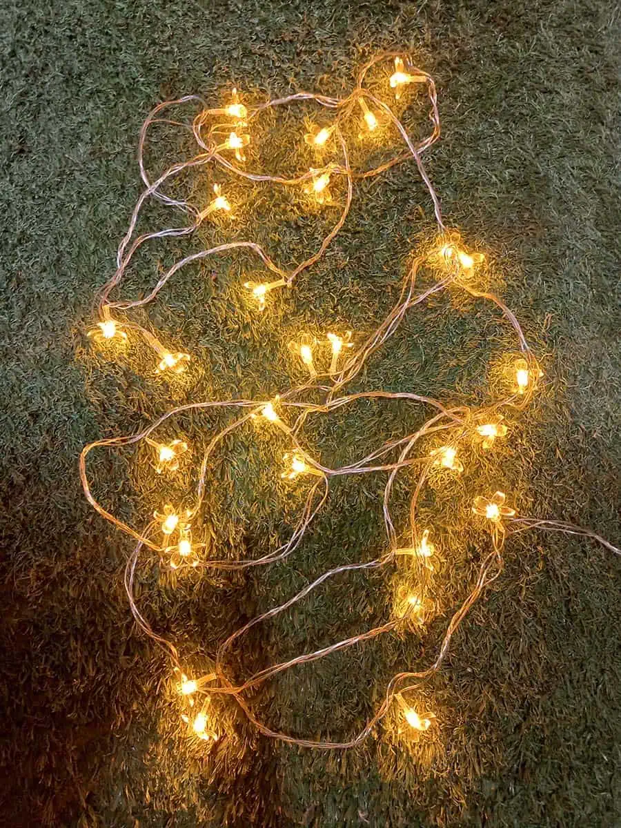 imagen de una tira de luces decorativa larga de flores calidas con enchufe