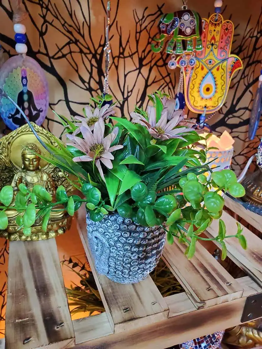 Maceta con cara de Buda con flores bordo artificiales