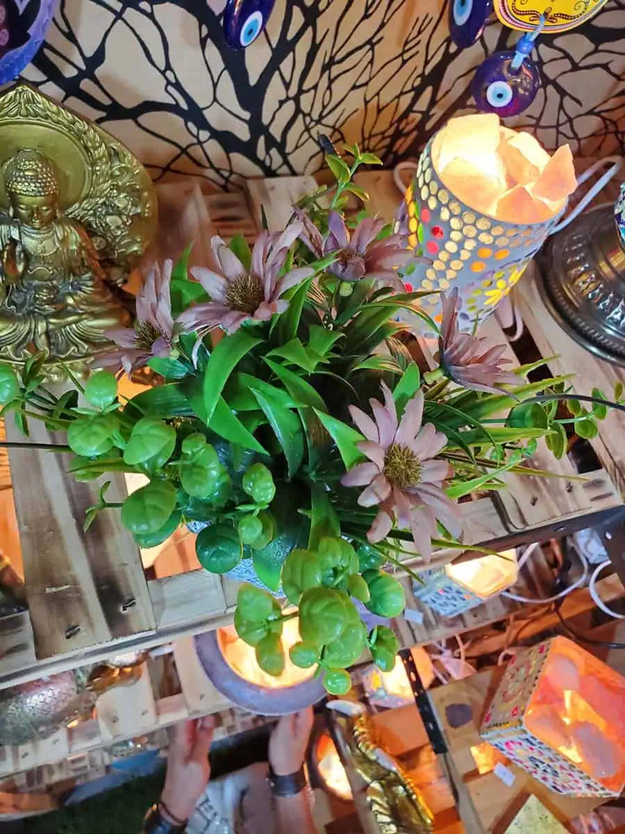 Maceta con cara de Buda con flores bordo artificiales