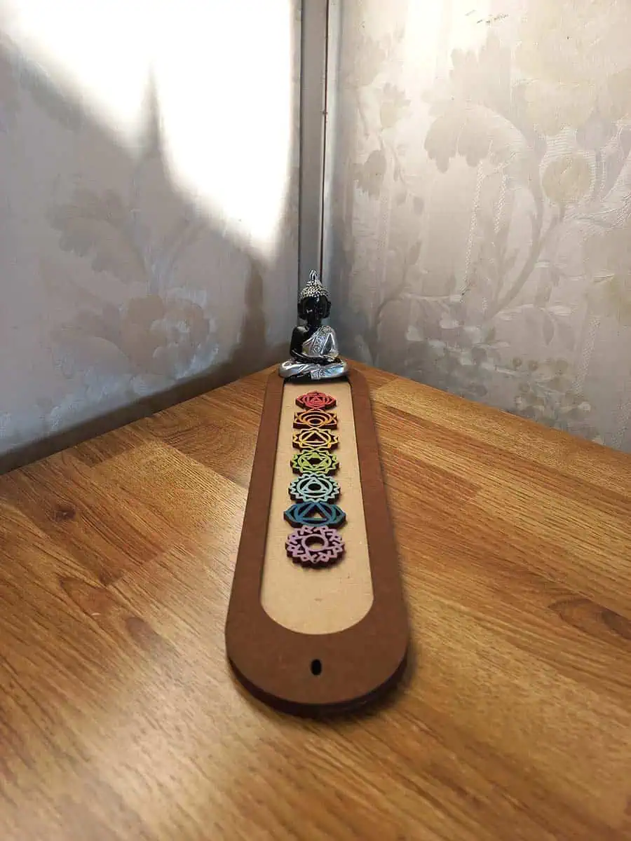imagen de un portasahumerio de madera lindo con los 7 chakras y un buidta o ganesha