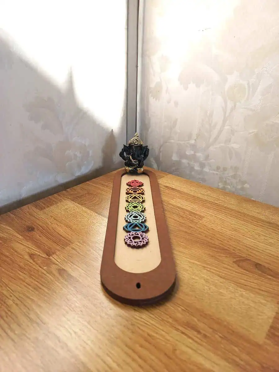 imagen de un portasahumerio de madera lindo con los 7 chakras y un buidta o ganesha