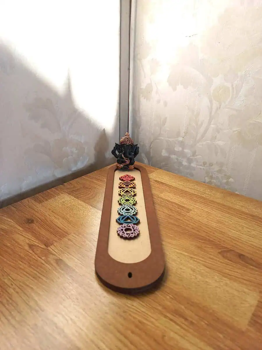 imagen de un portasahumerio de madera lindo con los 7 chakras y un buidta o ganesha
